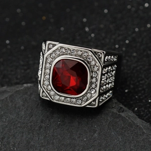 Macro detail of men's stainless steel ring with square red gemstone and pavé diamonds
