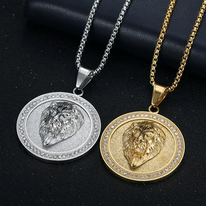 Nahaufnahme von Löwenkopf-Anhängern in Gold und Silber mit funkelndem Kristallbesatz