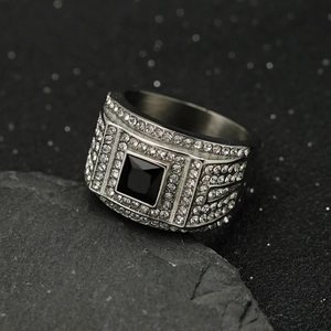 Macro shot of men's wide stainless steel ring with square black stone and pavé white diamonds