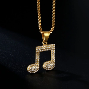 Golden musical note pendant necklace with sparkling rhinestones on a black background