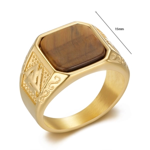 Detail of vintage gold-plated viking ring with square tiger eye stone and side engravings