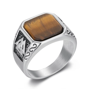 Macro detail of rectangle tiger eye stone and embossed viking runes on steel ring
