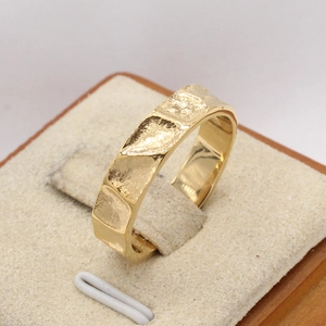Detailed view of golden hammered texture on stainless steel band ring surface
