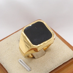 Gros plan d'une bague chevalière dorée avec résine noire sur support d'exposition