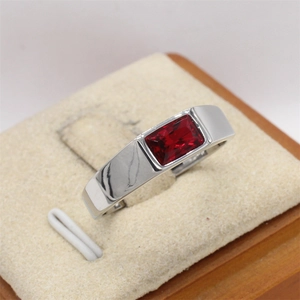 Detalle macro de un anillo ancho de plata con una gema roja profunda rectangular
