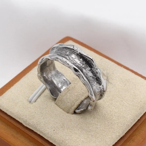 Makroaufnahme von Vintage Silberring mit Lavatextur und unregelmäßiger Metalloberfläche