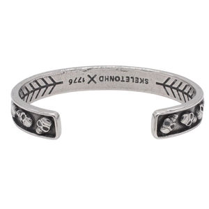 Retro stainless steel cuff bracelet with detailed 3D skull relief in vintage silver finish