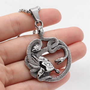 Retro Medusa snake head pendant necklace in vintage silver steel finish held in hand
