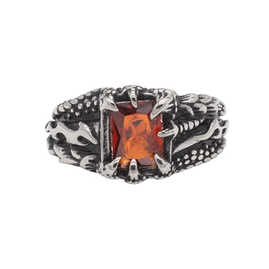Detail of retro dragon claw ring with red gemstone and textured scales engraving