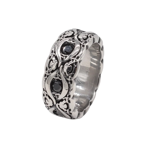 Macro view of retro silver ring with gothic relief and black gemstone inlay
