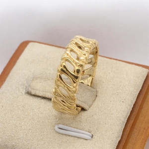 Retro hollowed bone structure gold titanium steel ring for men on beige display stand