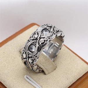 Detailed view of vintage titanium steel ring with intricate carvings and inset zircons