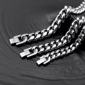 Polished stainless steel Cuban link chains in three sizes with square clasp on black background