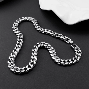 Macro view of polished silver Cuban link chain with a heavy square industrial clasp