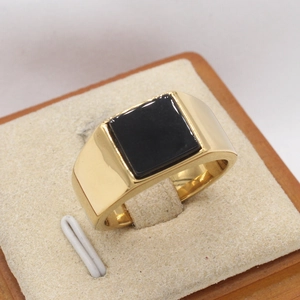 Classic gold titanium steel signet ring with a minimalist square black stone on a display