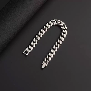 Macro detail of silver stainless steel Cuban link bracelet with square clasp closure