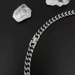 Detailed view of polished silver cuban link chain with fold-over clasp on black background