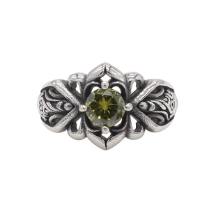 Dettaglio di anello vintage con gemma verde oliva e trama d'argento goffrata fine