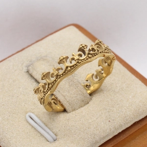 Gros plan détaillé d'une bague couronne dorée vintage avec motifs ajourés