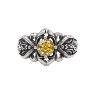 Dettaglio macro di anello vintage in acciaio al titanio con motivi gotici e pietra gialla
