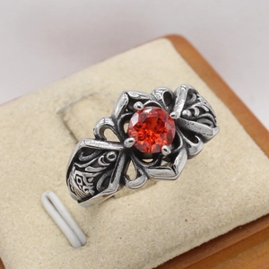 Dettaglio macro di un anello vintage gotico in acciaio al titanio con rubino rosso rotondo
