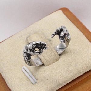 Retro silver handshake ring with vintage metal texture on beige velvet jewelry display