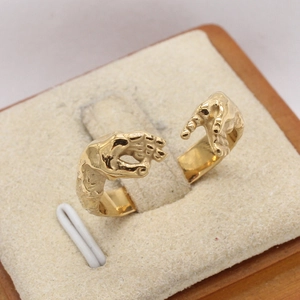 Retro golden handshake open ring featuring two hands touching on a beige velvet display