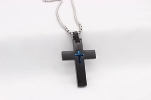 Détail du pendentif croix en acier noir brossé avec croix bleue et chaîne argentée