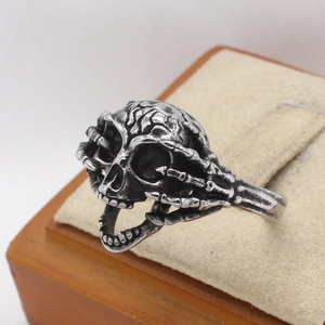 Vintage silver skull ring with skeletal hands wrap design in retro gothic style