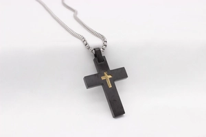 Détail du pendentif croix avec couche noire mate et croix intérieure en or poli