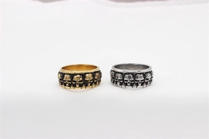 Detailed close-up showing vintage gold and silver skull relief rings with oxidized finish