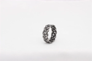 Macro detail of retro woven Viking Celtic steel ring with vintage oxidized finish