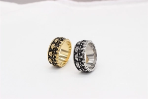 Close-up of gold and silver gothic skull relief rings with detailed steel carving