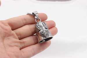 Macro view of vintage stainless steel bell pendant with heart and wing relief details