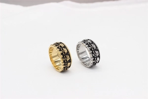 Macro shot of gold and silver retro skull embossed rings in punk gothic style metal