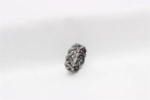 Detailed view of vintage Viking Celtic woven texture on steel ring with oxidized finish