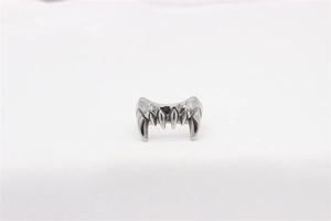 Détail macro d'une bague en acier argenté en forme de crocs avec finition polie