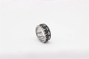 Detailed close-up of embossed skull patterns on a vintage punk stainless steel ring band