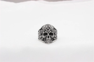 Detailed close-up of vintage Masonic skull ring with ornate engravings and silver finish