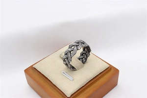 Macro shot of vintage woven Celtic pattern on wide stainless steel viking ring for men