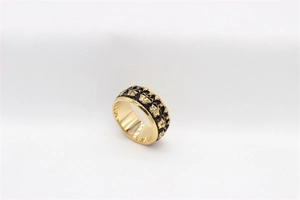 Macro shot of gold vintage skull ring showing intricate black embossed bee patterns