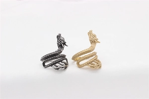 Close-up of golden and silver vintage dragon rings with detailed scales and engraved heads