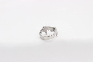 Vue détaillée d'une bague crocs de monstre argentée avec design punk sur tissu blanc