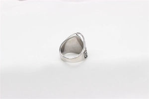 Close-up of vintage steel skull ring with black engraved patterns and retro texture