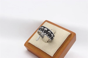 Macro shot of vintage skull pattern and oxidized finish on wide steel band ring