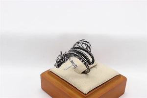 Macro detail of retro dragon ring with intricate scales and vintage steel finish