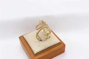 Detailed close-up of golden dragon ring with intricate scale textures on jewelry stand