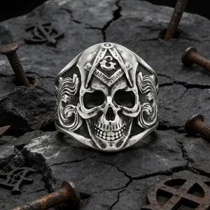 Vintage silver skull ring with Freemasonry symbol G on a dark industrial background