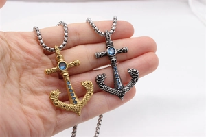 Detail view of retro anchor and cross pendant with blue gemstone and gothic nautical engraving