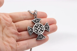 Close-up of vintage silver viking cross pendant with intricate celtic knot relief details
